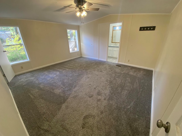 carpeted empty room with ceiling fan, crown molding, and lofted ceiling