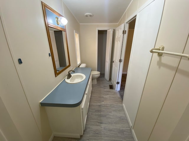 bathroom with hardwood / wood-style floors, vanity, and toilet