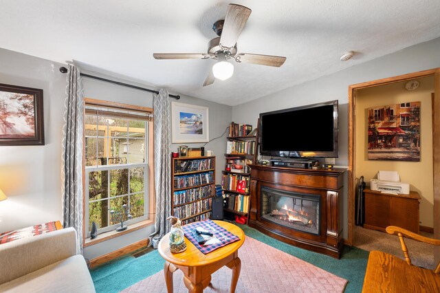 living room featuring carpet, a textured ceiling, and ceiling fan