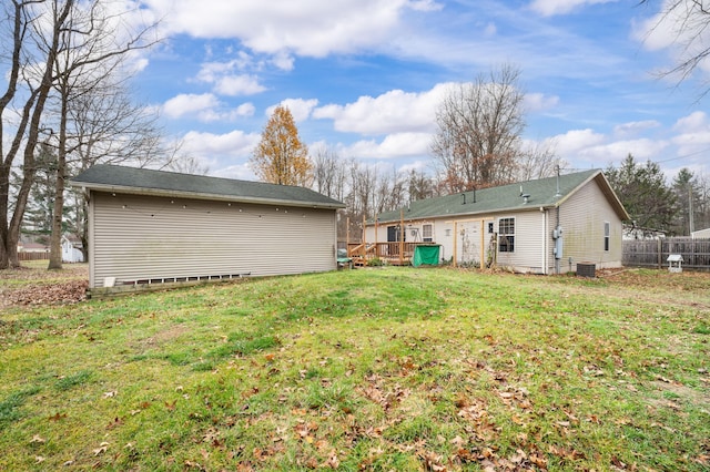 back of house featuring central AC unit and a lawn