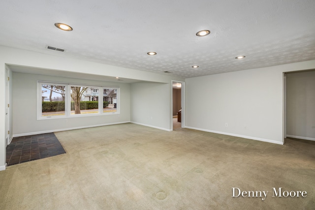 unfurnished living room with carpet flooring and a textured ceiling