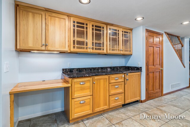 kitchen featuring light tile patterned flooring and dark stone counters