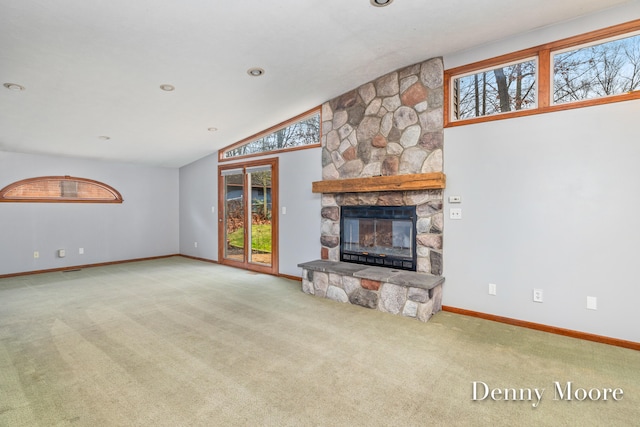 unfurnished living room featuring a stone fireplace, light colored carpet, and lofted ceiling