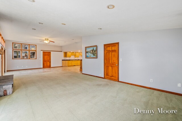 unfurnished living room featuring ceiling fan, lofted ceiling, and light carpet