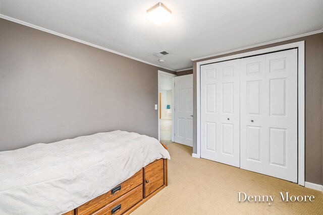 bedroom with crown molding, light carpet, and a closet