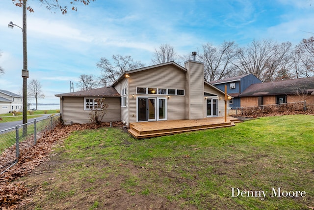 back of house featuring a deck and a yard