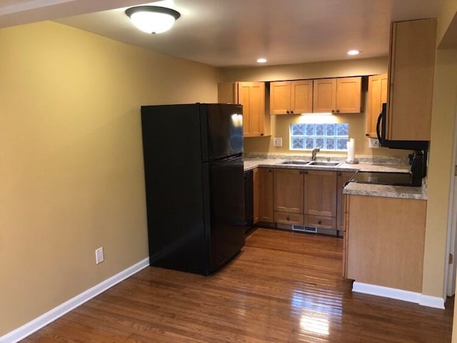 kitchen with dark hardwood / wood-style flooring, black appliances, and sink