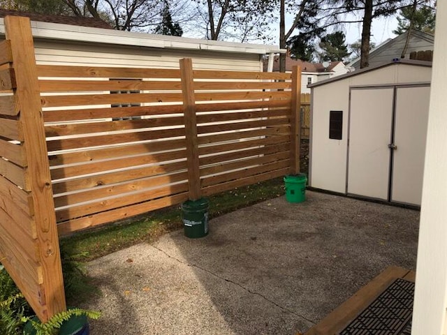 view of gate with a storage unit and a patio area