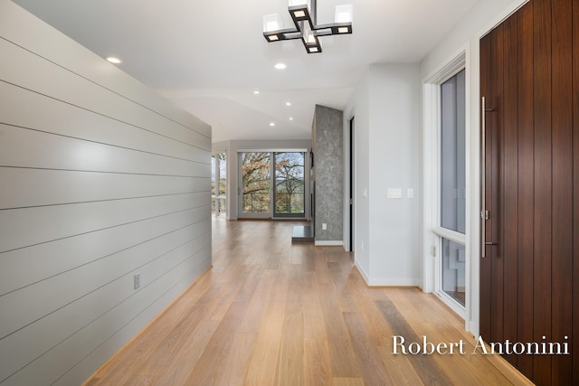 corridor with lofted ceiling and light hardwood / wood-style flooring