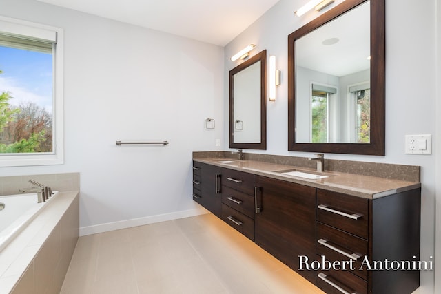 bathroom featuring vanity and tiled tub