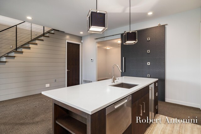 kitchen featuring dishwasher, dark colored carpet, a center island with sink, and sink