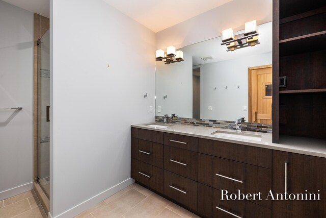 bathroom featuring tile patterned flooring, vanity, tasteful backsplash, and walk in shower