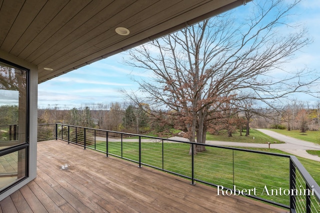 wooden deck featuring a lawn