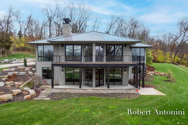 back of property with a lawn and a patio