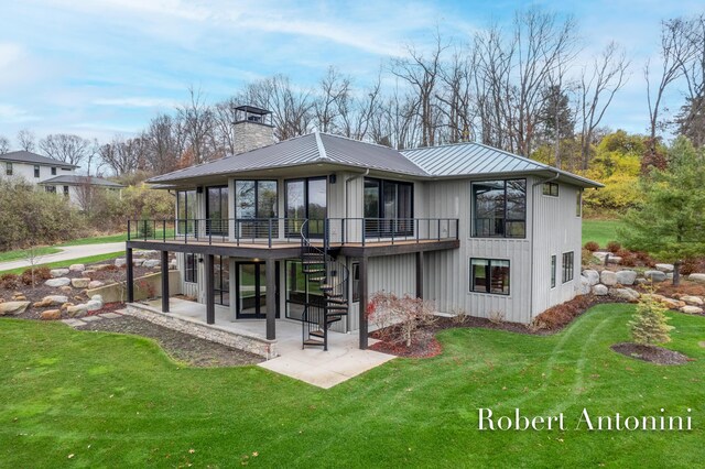 rear view of property featuring a lawn, a patio area, and a deck