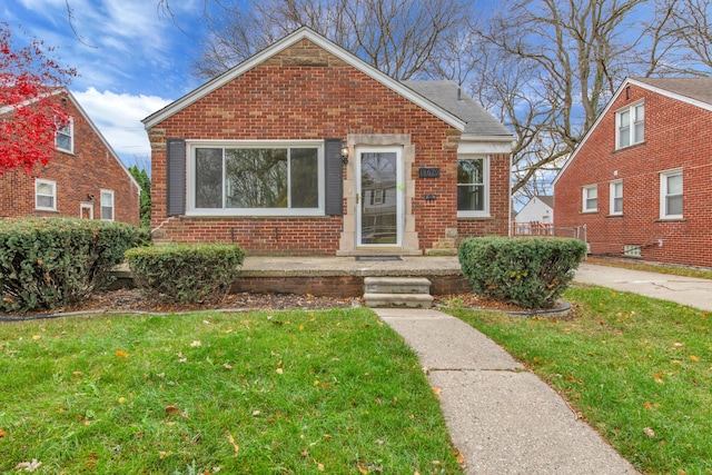 bungalow-style home featuring a front lawn