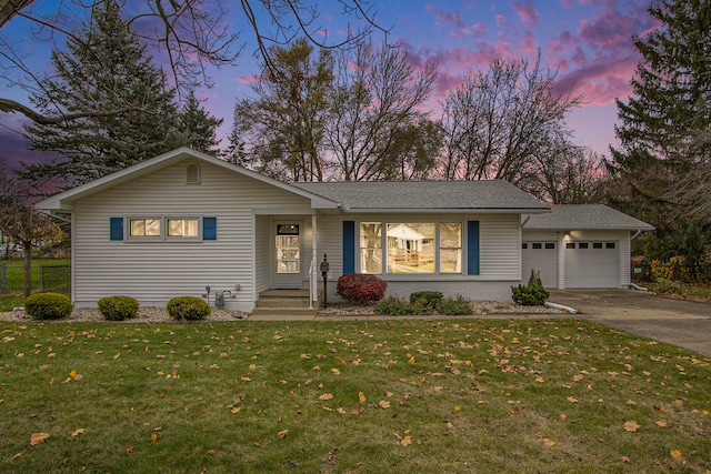 ranch-style home with a yard and a garage