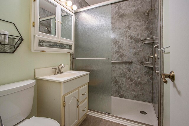 bathroom with a shower with door, vanity, and toilet