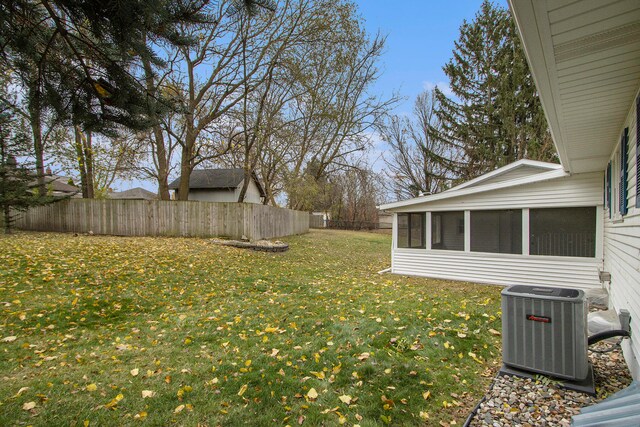 view of yard with central air condition unit and a sunroom