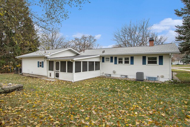 back of property featuring a sunroom, cooling unit, and a yard