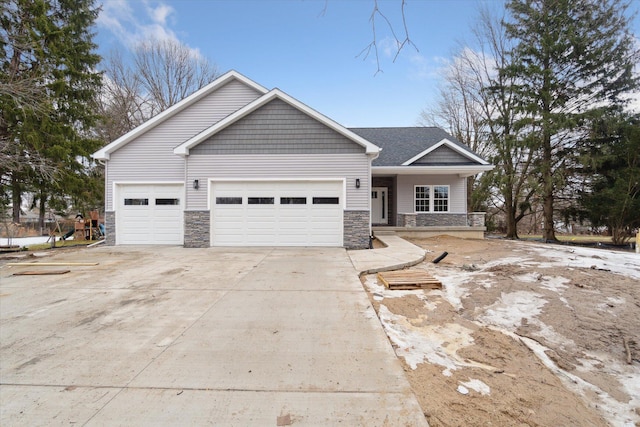 view of front facade featuring an attached garage, stone siding, and concrete driveway