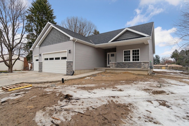 view of front of house featuring an attached garage, stone siding, driveway, and roof with shingles