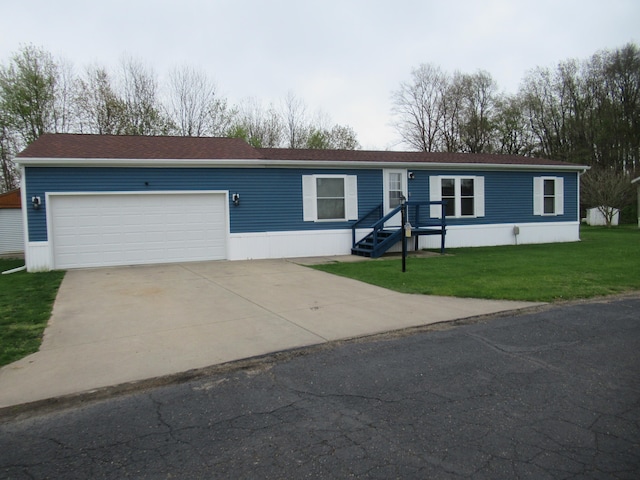 manufactured / mobile home featuring a garage and a front lawn