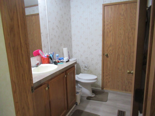 bathroom featuring hardwood / wood-style floors, vanity, and toilet