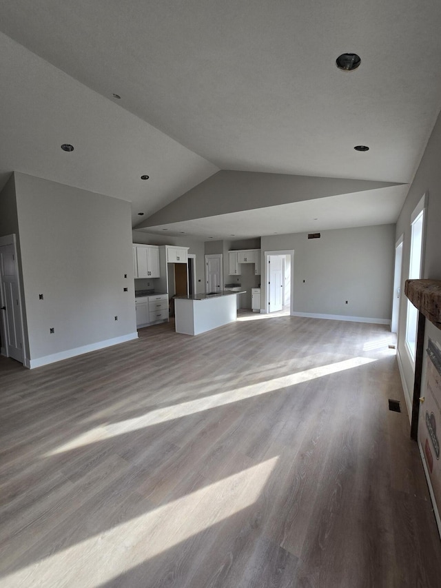 unfurnished living room with light hardwood / wood-style floors and lofted ceiling