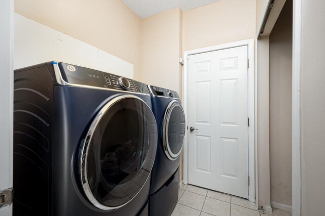 laundry room featuring light tile patterned floors and washer and dryer