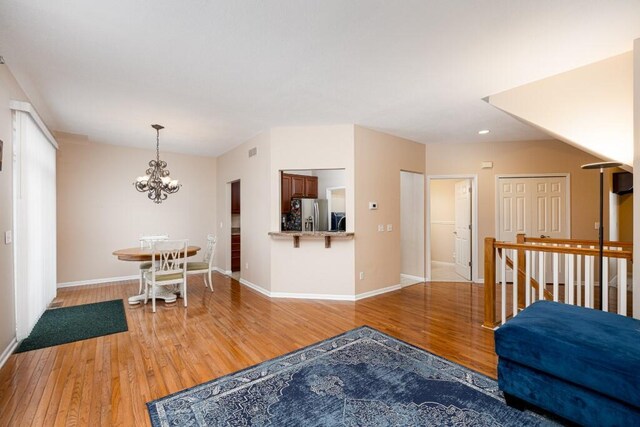 living room with light wood-type flooring and an inviting chandelier