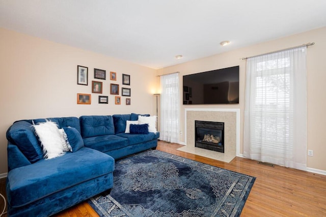 living room with hardwood / wood-style flooring and a tiled fireplace