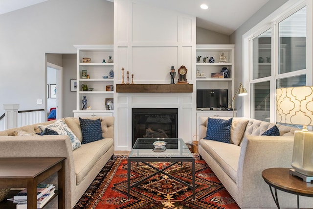 living room with built in shelves and lofted ceiling