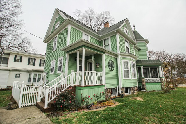 view of front facade with a sunroom and a front lawn