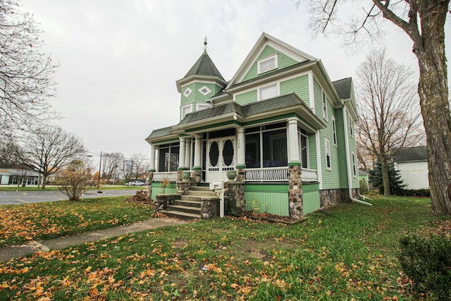 victorian-style house with a porch and a front lawn