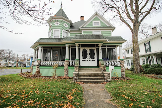 victorian home with covered porch and a front lawn