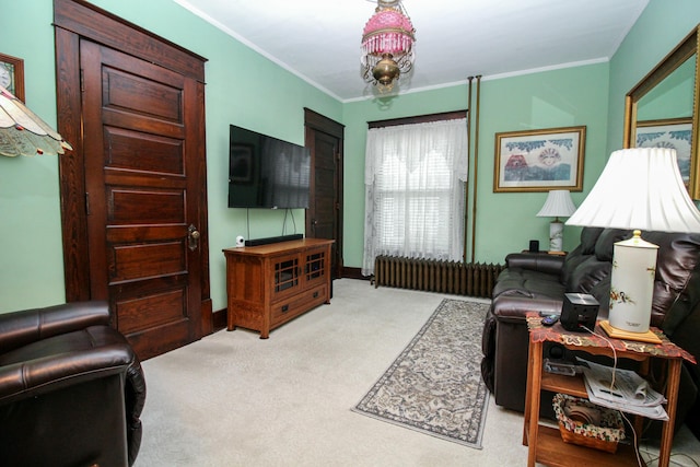 carpeted living room with a chandelier, radiator heating unit, and ornamental molding