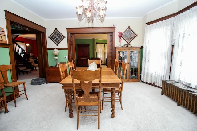 dining space featuring light carpet, a chandelier, radiator, and crown molding