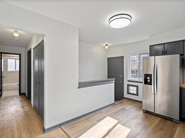 kitchen with stainless steel fridge with ice dispenser and light hardwood / wood-style floors