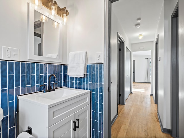 bathroom featuring backsplash, vanity, tile walls, and hardwood / wood-style flooring