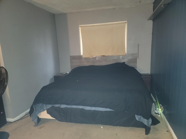 carpeted bedroom featuring wooden walls