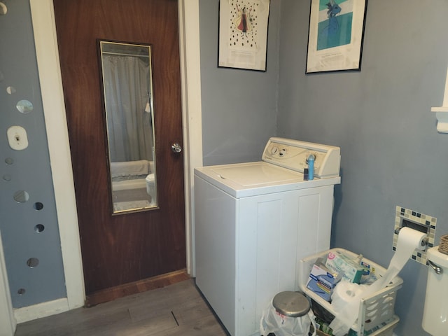 clothes washing area with washer / dryer and dark wood-type flooring