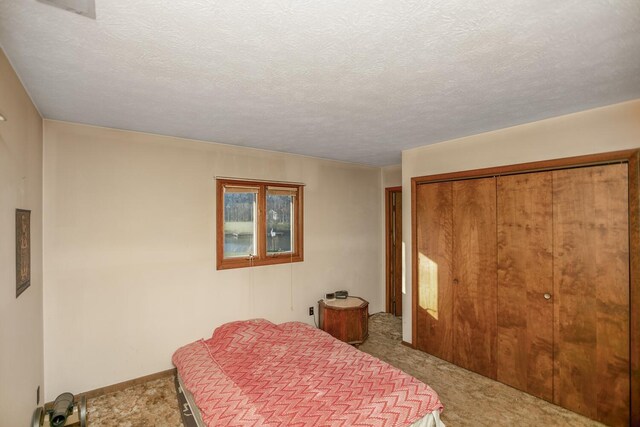 carpeted bedroom with a closet and a textured ceiling