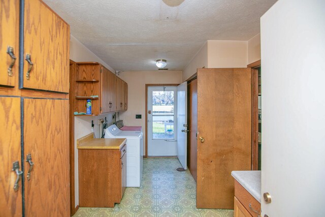 kitchen with a textured ceiling and independent washer and dryer