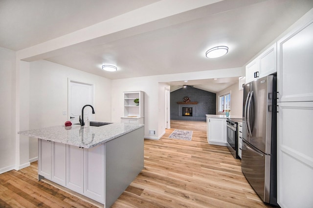 kitchen featuring sink, white cabinets, a kitchen island with sink, stainless steel appliances, and light stone countertops