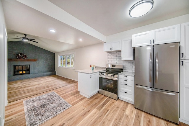 kitchen featuring white cabinetry, tasteful backsplash, vaulted ceiling, stainless steel appliances, and light hardwood / wood-style floors