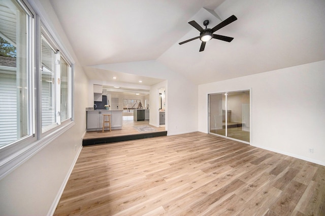 unfurnished living room featuring ceiling fan, vaulted ceiling, and light hardwood / wood-style flooring