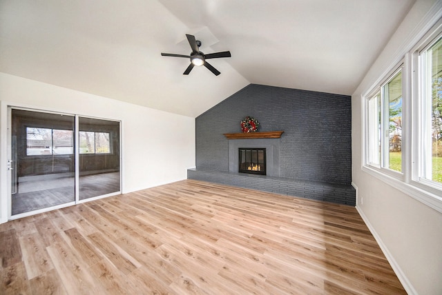 unfurnished living room featuring lofted ceiling, a fireplace, ceiling fan, and light wood-type flooring