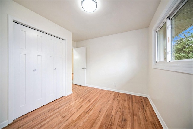 unfurnished bedroom with light hardwood / wood-style floors and a closet