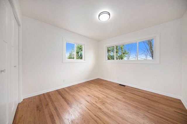 empty room with hardwood / wood-style flooring and vaulted ceiling